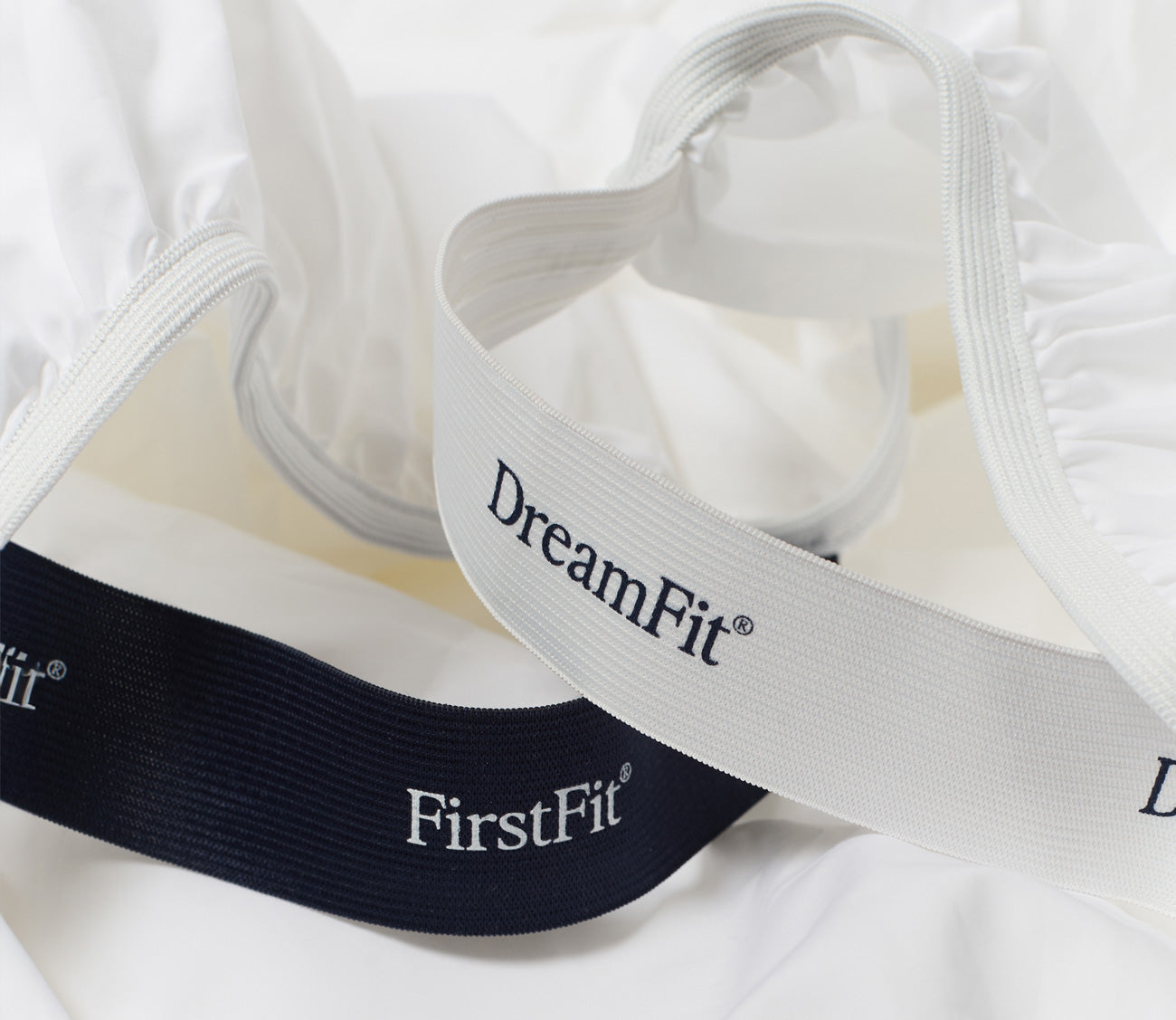 Close-up of scure fit bands with 'DreamFit' and 'FirstFit' branding on a white background