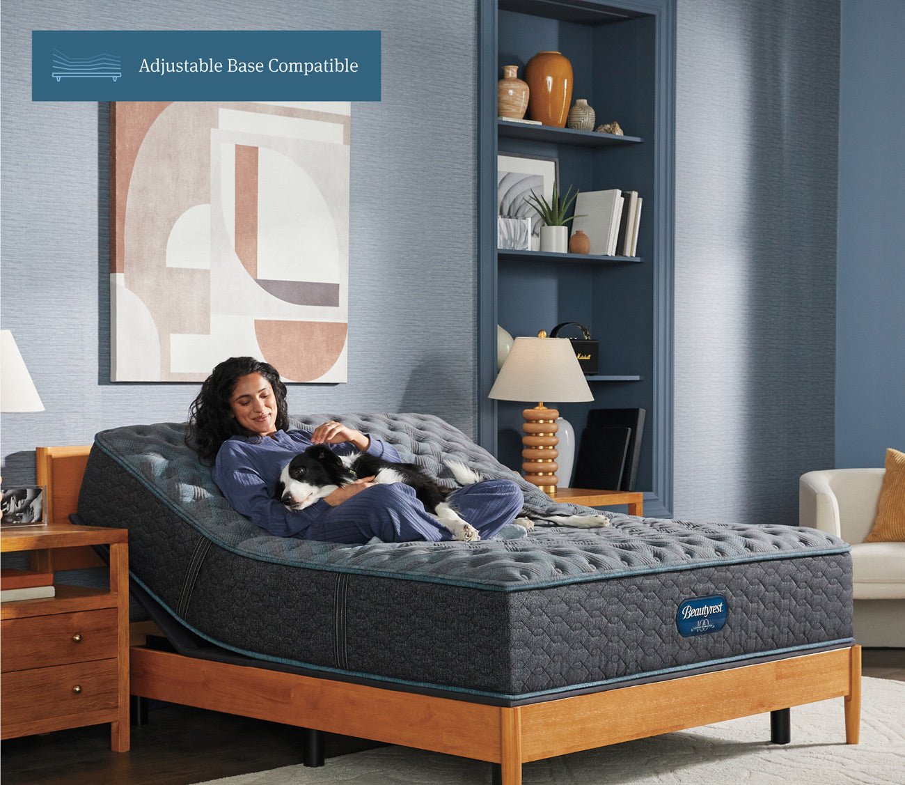 A woman and a dog  comfortably laying down on a Beautyrest Tortuga Bay Medium Innerspring Mattress showcasing adjustable base compatibility.