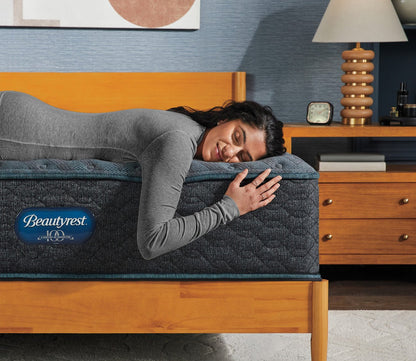 A woman laying down on a Beautyrest Tortuga Bay Medium Innerspring Mattress in a lifestyle setting