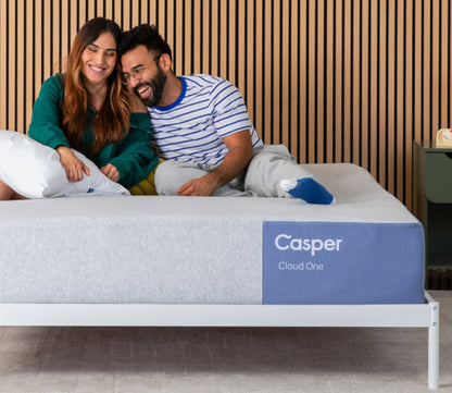 Woman and man resting and smiling on top of Casper Cloud One Mattress.