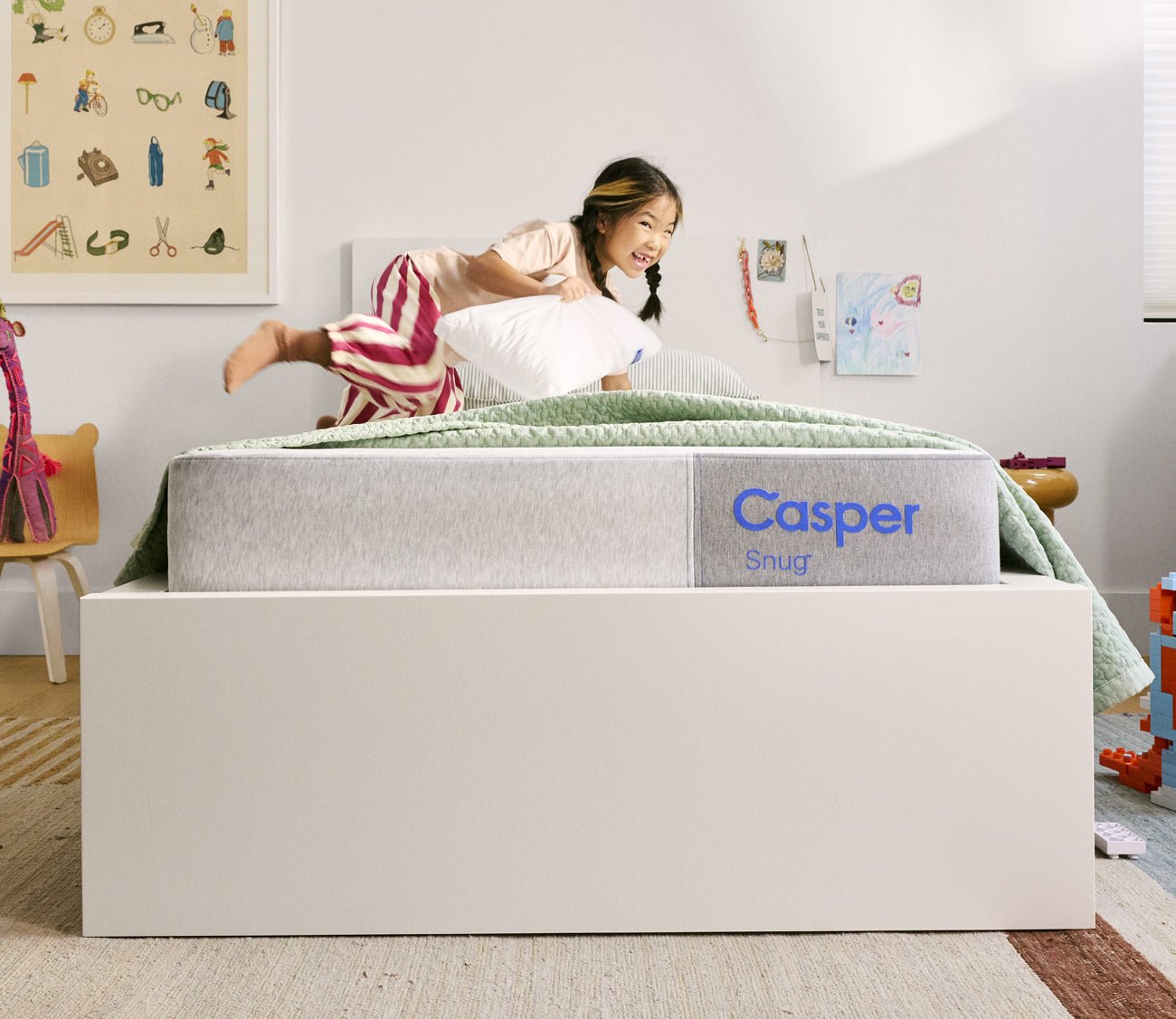 Child playing on Casper Snug Kid's Mattress by Casper