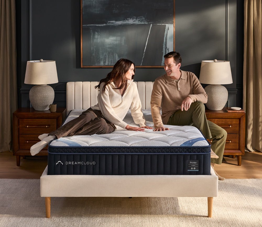 Womand and man sitting on DreamCloud 4.0 Premier Hybrid Mattress by DreamCloud.