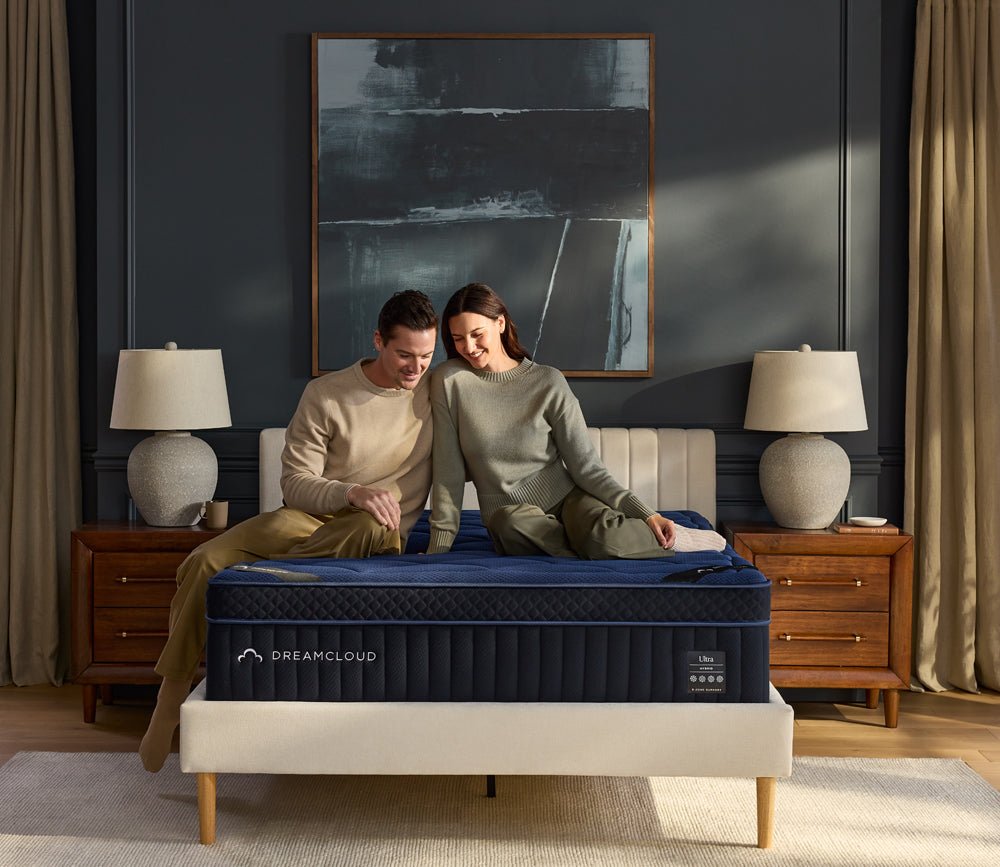 Womand and men sitting on DreamCloud 4.0 Ultra Hybrid Mattress.