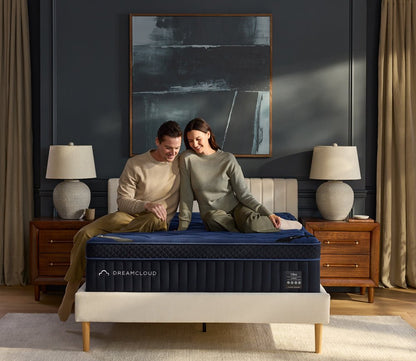 Womand and men sitting on DreamCloud 4.0 Ultra Hybrid Mattress.
