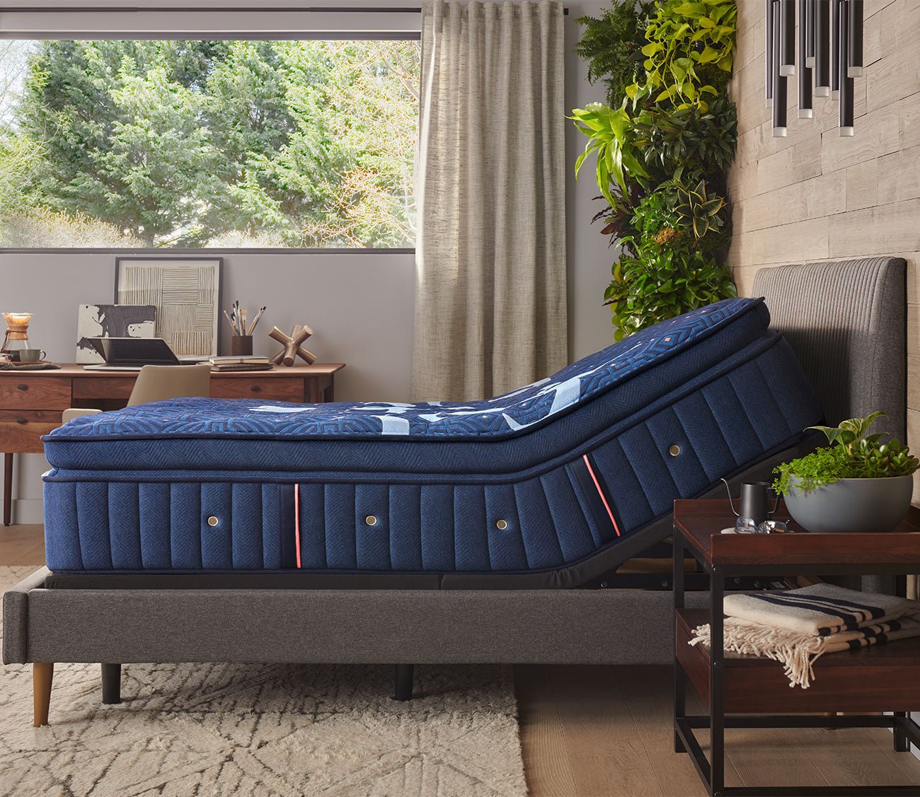 Lux Estate Firm Euro Pillow Top Mattress on an adjustable base in a lifestyle setting - side view.