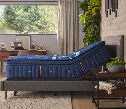 Lux Estate Firm Euro Pillow Top Mattress on an adjustable base in a lifestyle setting - side view.
