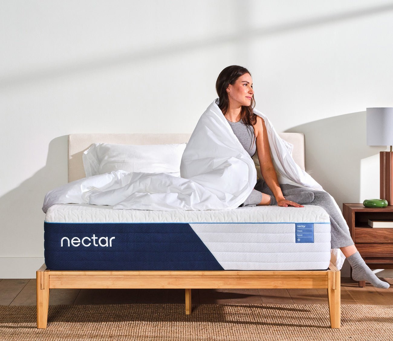 A woman relaxing on a Nectar 5.1 Classic Hybrid Mattress