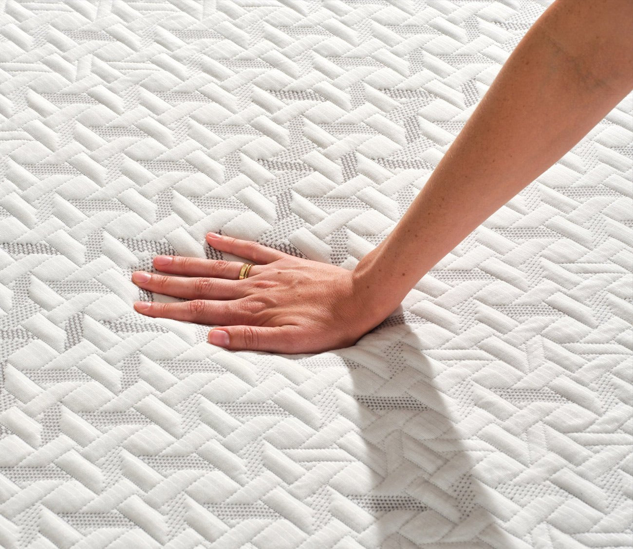 Hand pressing on Nectar 5.1 Classic Hybrid Mattress cover to demonstrate pressure relief and comfort.