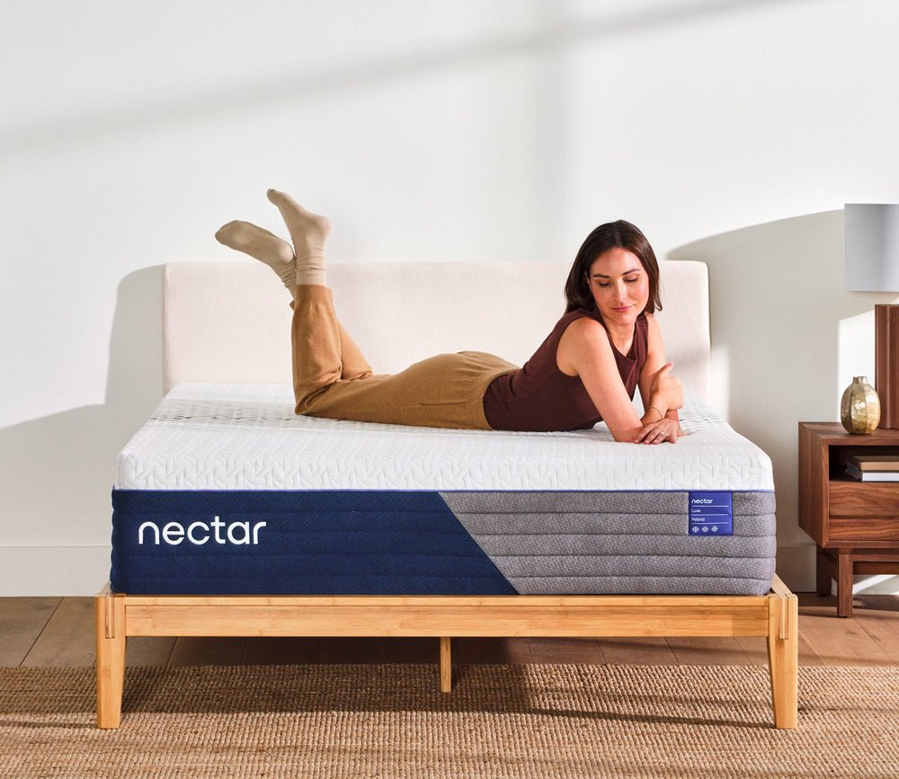 Woman resting on Nectar 5.1 Luxe Hybrid Mattress.