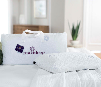 PranaSleep Asha Natural Latex Pillow displayed with branded carrying case in a serene bedroom setting.