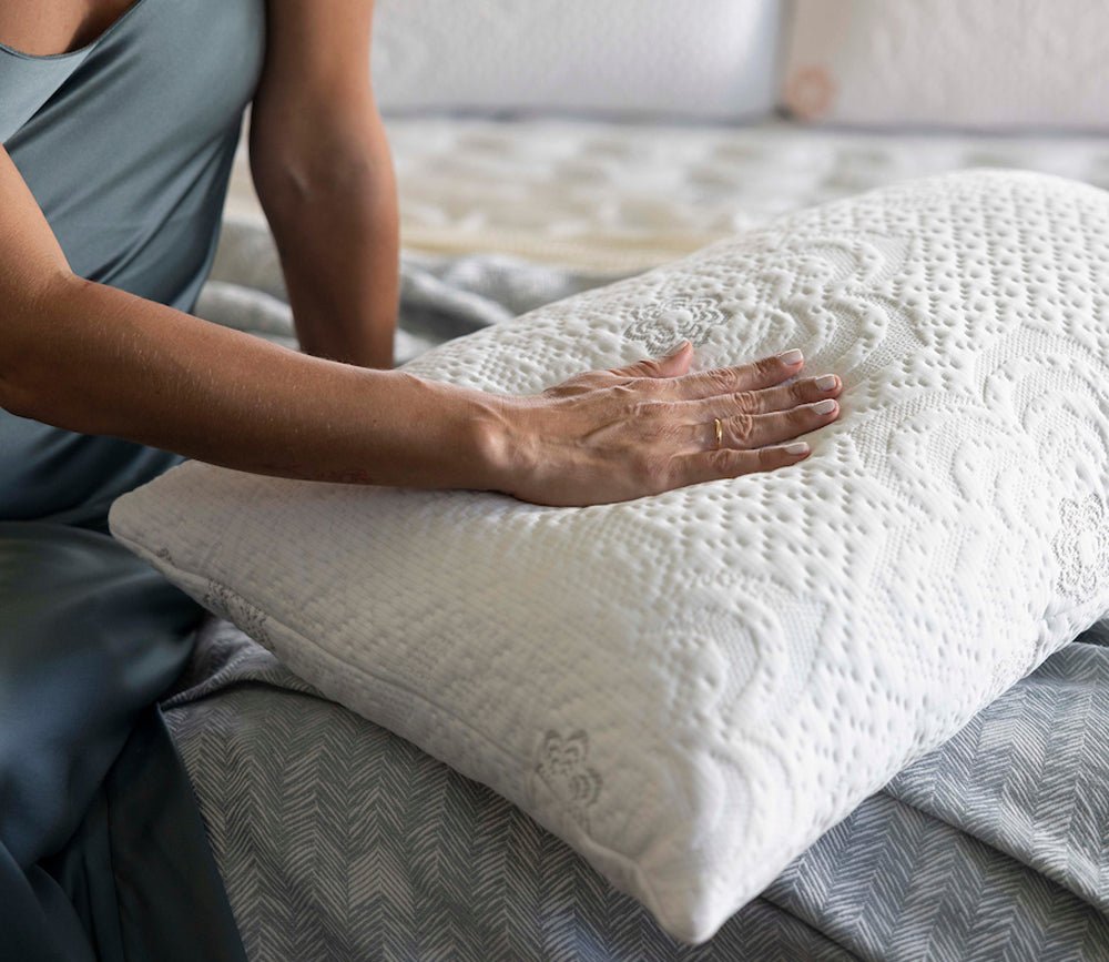 Hand pressing the PranaSleep Dharma Adjustable Latex Pillow, highlighting its plush comfort and responsive support.