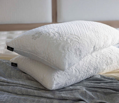 Two PranaSleep Dharma Adjustable Latex Pillows stacked on a bed, showcasing their textured knit covers and premium design.