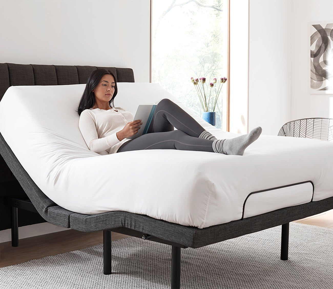 S1000 Adjustable Bed Base by Sleeptone, woman reading in bed with head elevated