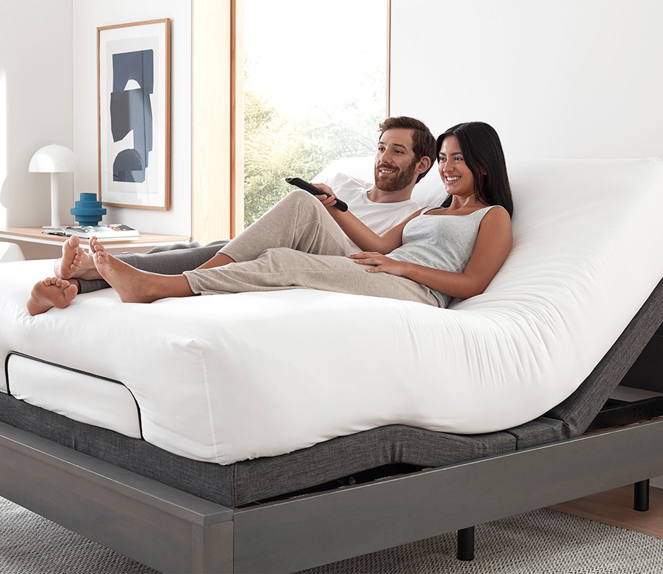 S3000 Adjustable Bed Base by Sleeptone, couple in bed relaxing with head and legs adjusted
