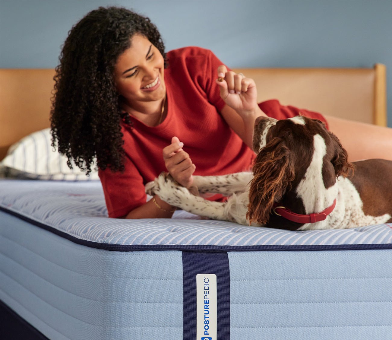 Woman and dog resting on Sealy Posturepedic Spring Medina Soft Mattress by Sealy
