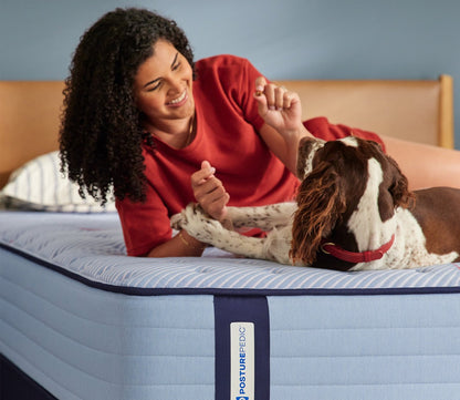 Woman and dog resting on Sealy Posturepedic Spring Medina Soft Mattress by Sealy