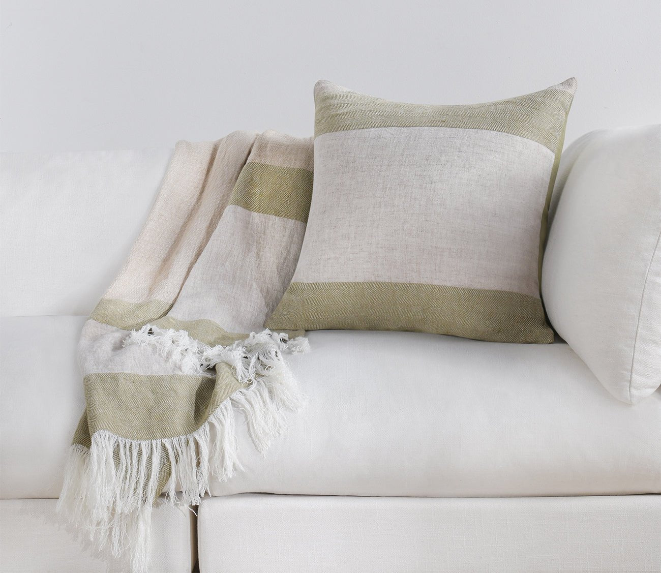 Talara Crafted Throw Blanket by Villa by Classic Home in green on sofa